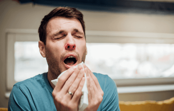 Homeowner sneezing from dust circulating through dirty air ducts