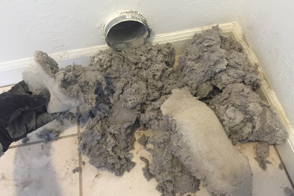 Colair technician professionally cleaning lint out of a dryer vent
