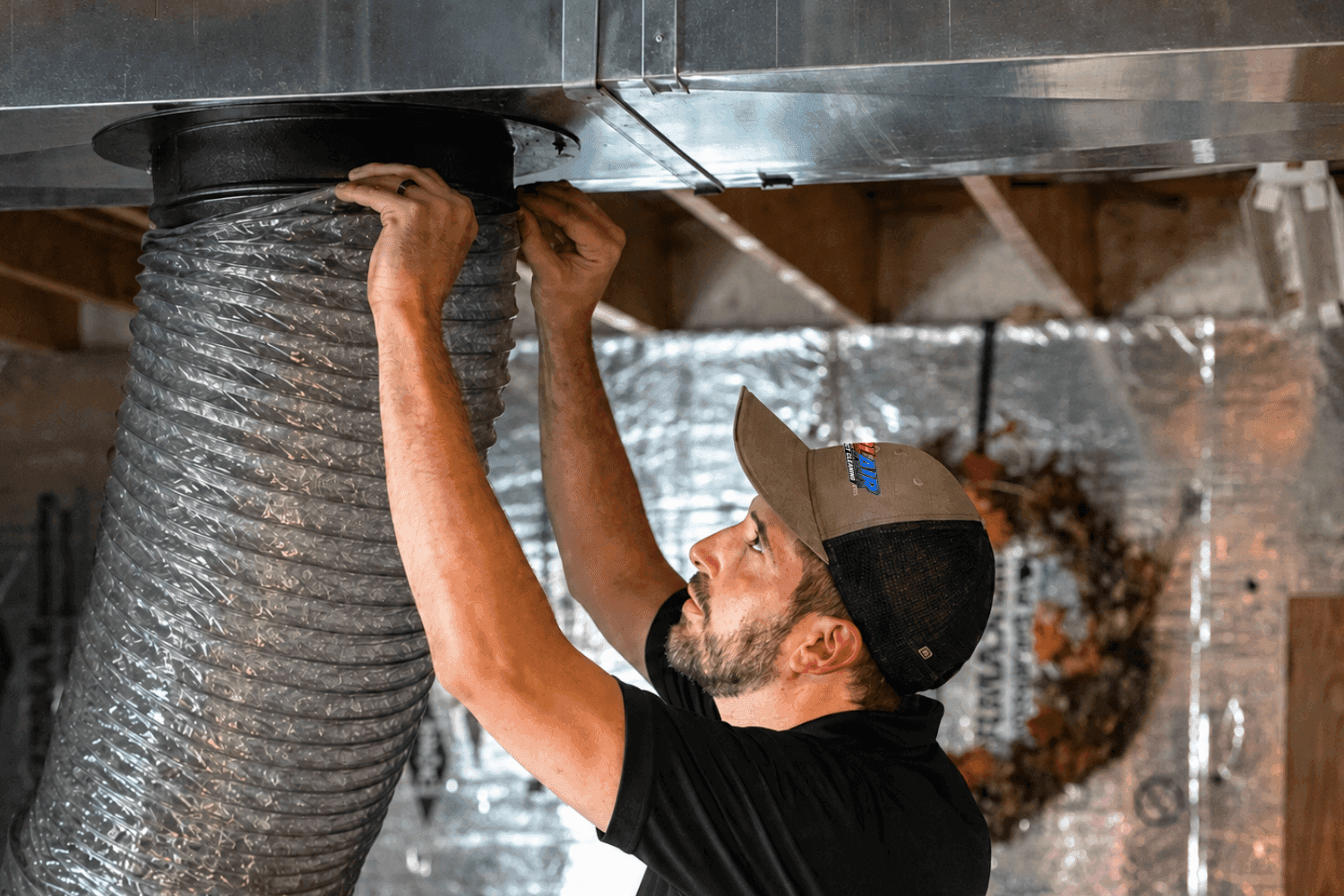 Colair technician connecting flex ductwork during a residential duct cleaning