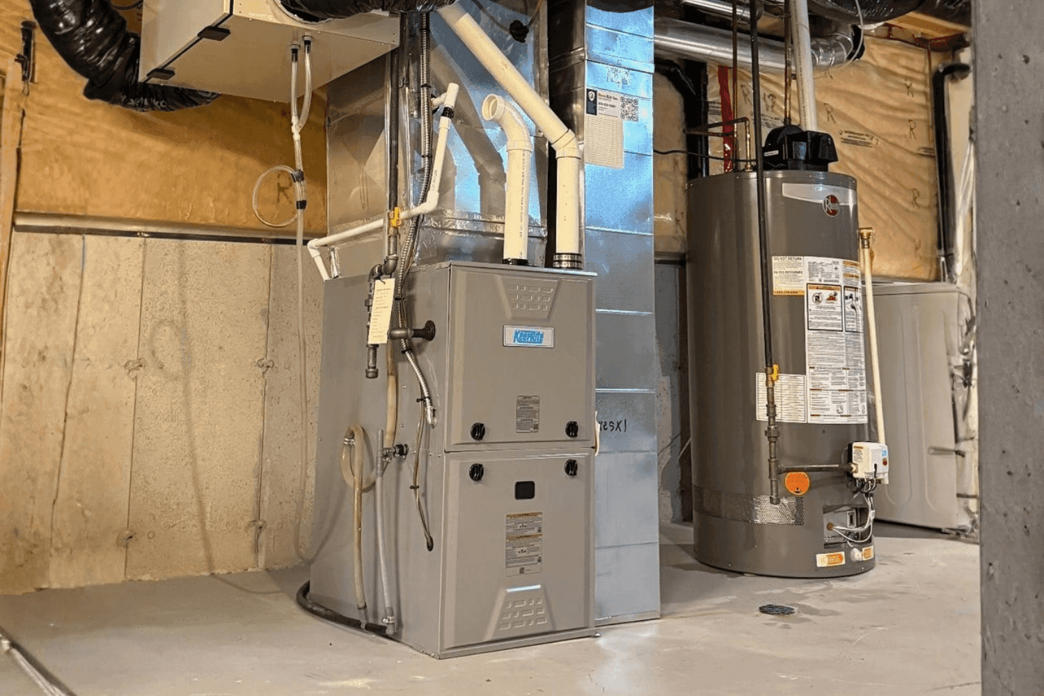 New high-efficiency furnace installed next to a water heater in an Ottawa basement
